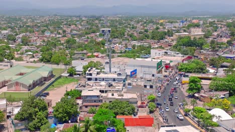 aerial following shot of cable car transport over city of alcarrizos during sunny day - dominican republic, santo domingo