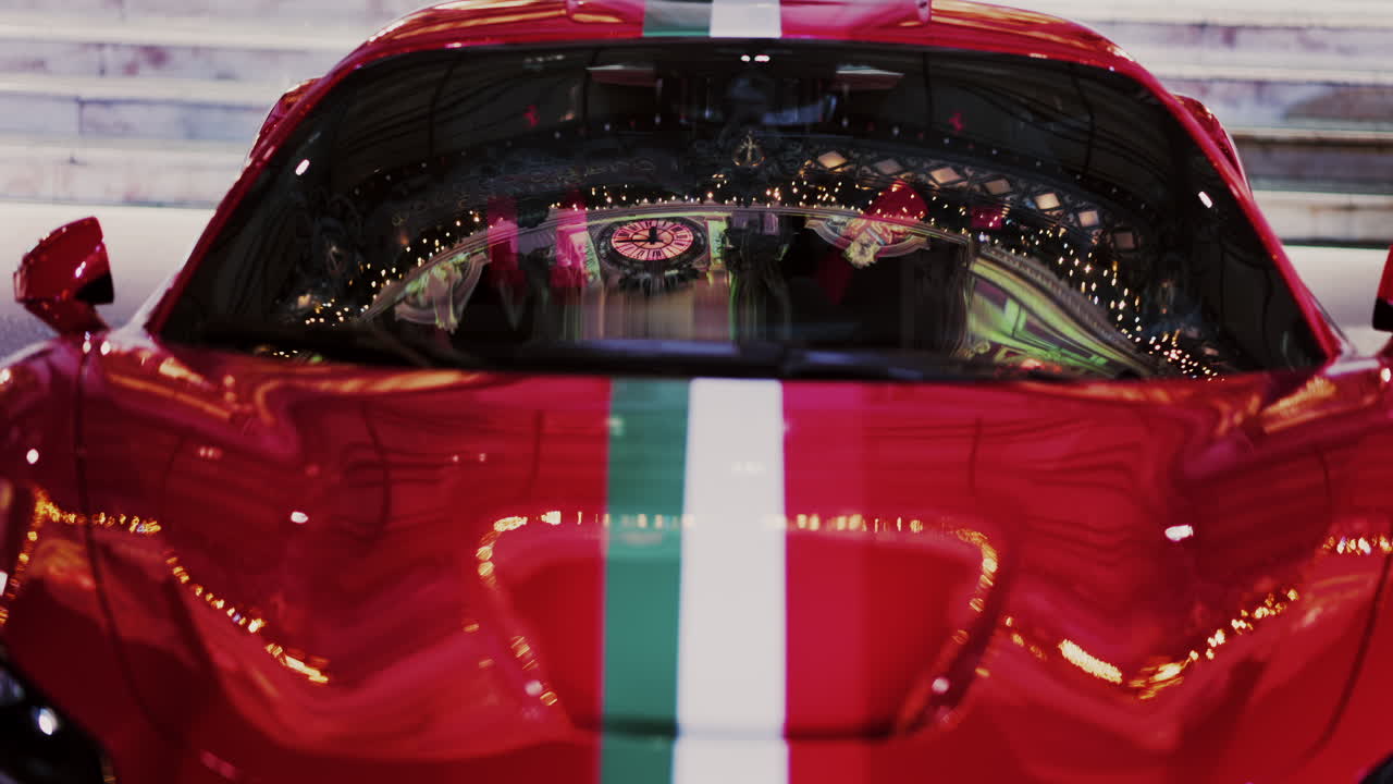 Close up of a red car with the Italian flag on it in the courtyard of the Monte Carlo Casino in the evening in Monaco