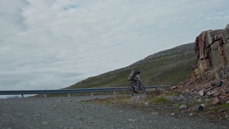ciclista en bicicleta por un camino áspero cuesta arriba de montaña en noruega