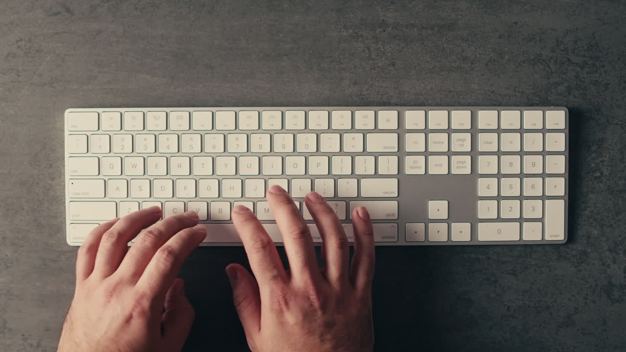 Person Typing on a White Keyboard