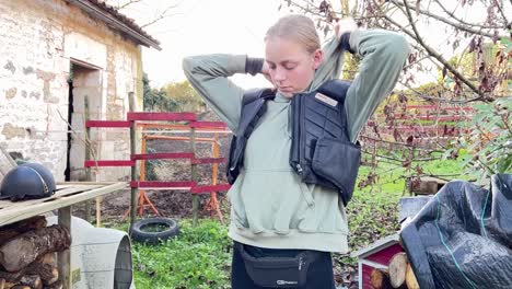 female jockey puts on her leather vest