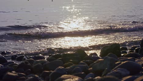 sun reflection at the sea on a rocky beach