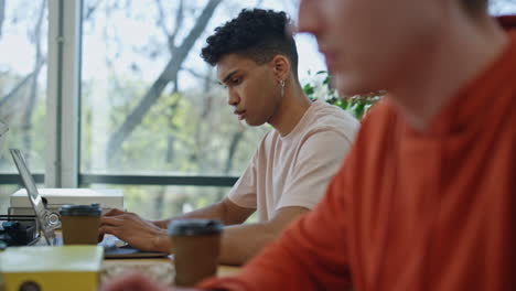 diverse guys working computers at office blur effect. man hands typing laptop