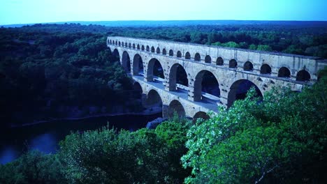 drone tiro de la vieja tubería de agua de los romanos con arcos de piedra sobre un río en francia entre la naturaleza en buen tiempo