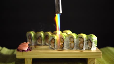 sushi in black background being flame torched