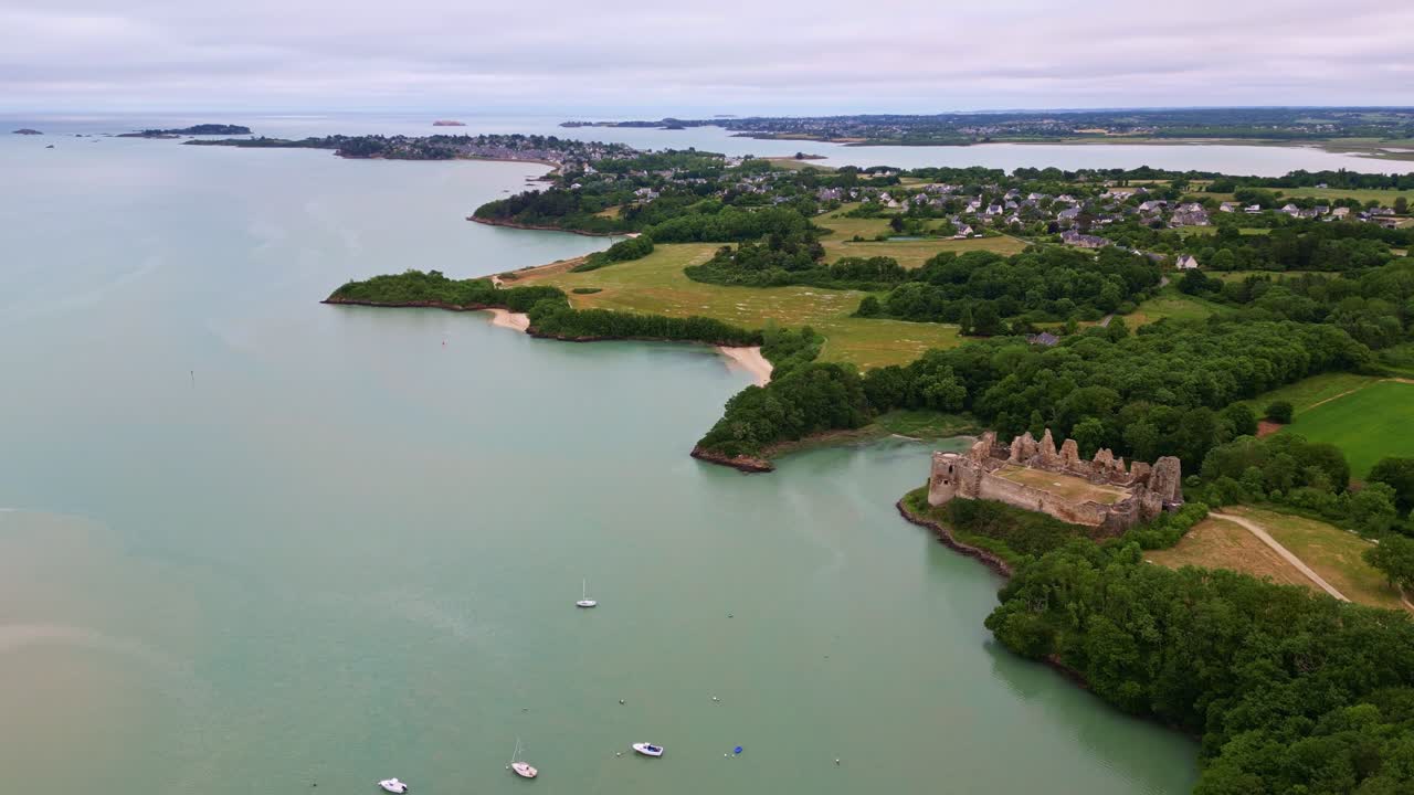 Historic ruins of Château du Guildo castle at mouth of Arguenon river, Brittany coastline, Saint-Jacut-de-la-Mer, France. Aerial drone descending