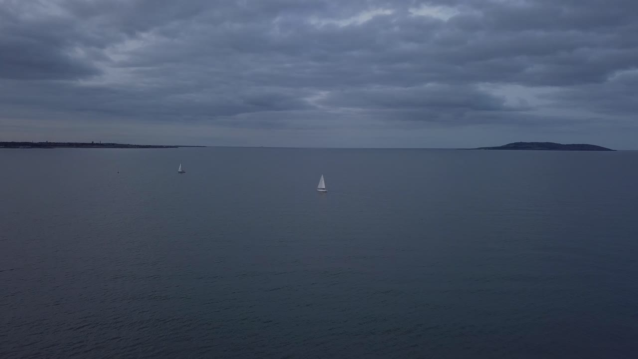 해안선 근처에서 두 척의 범선을 향해 비행하는 항공 영상