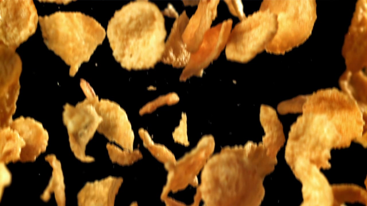 Golden Corn Flakes Falling in Slow Motion on Black Background