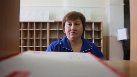 mujer trabajando en un mostrador de la oficina de correos