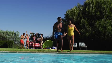 Eine-Vielfältige-Gruppe-Von-Freunden,-Die-Spaß-Daran-Haben,-In-Ein-Schwimmbad-Zu-Springen