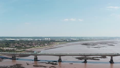 descending drone shot of road sea bridge with power station in the background