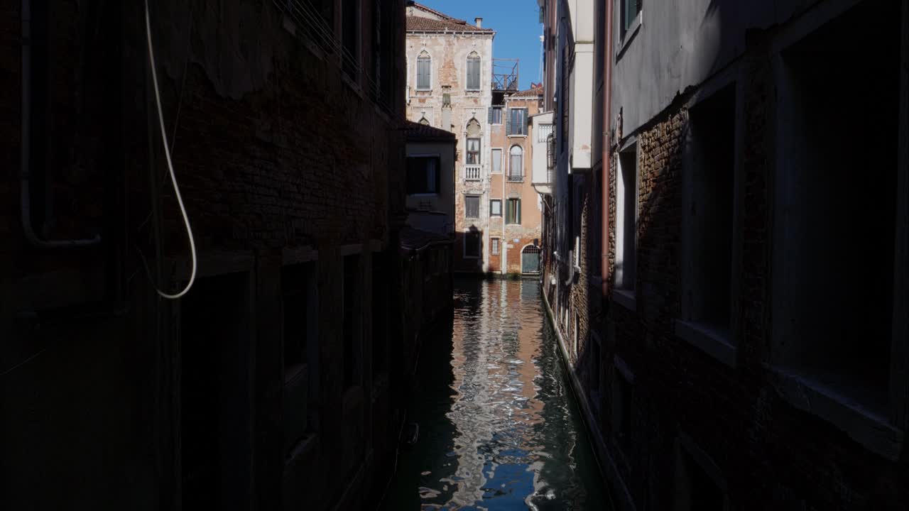 Quiet Venetian Canal Lined with Old Buildings and Reflections