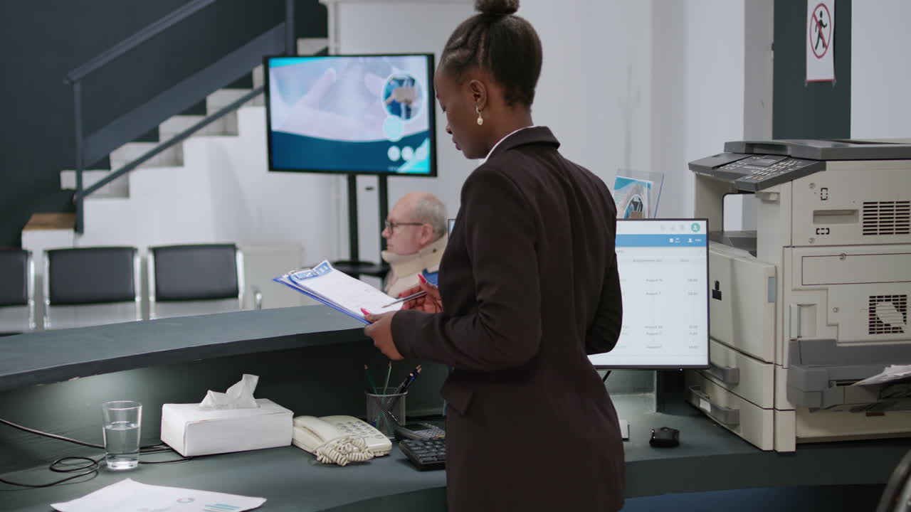 Man with cervical collar in hospital reception talking with the receptionist