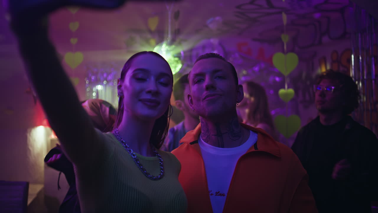 Party friends making selfie at neon party enjoying club atmosphere closeup