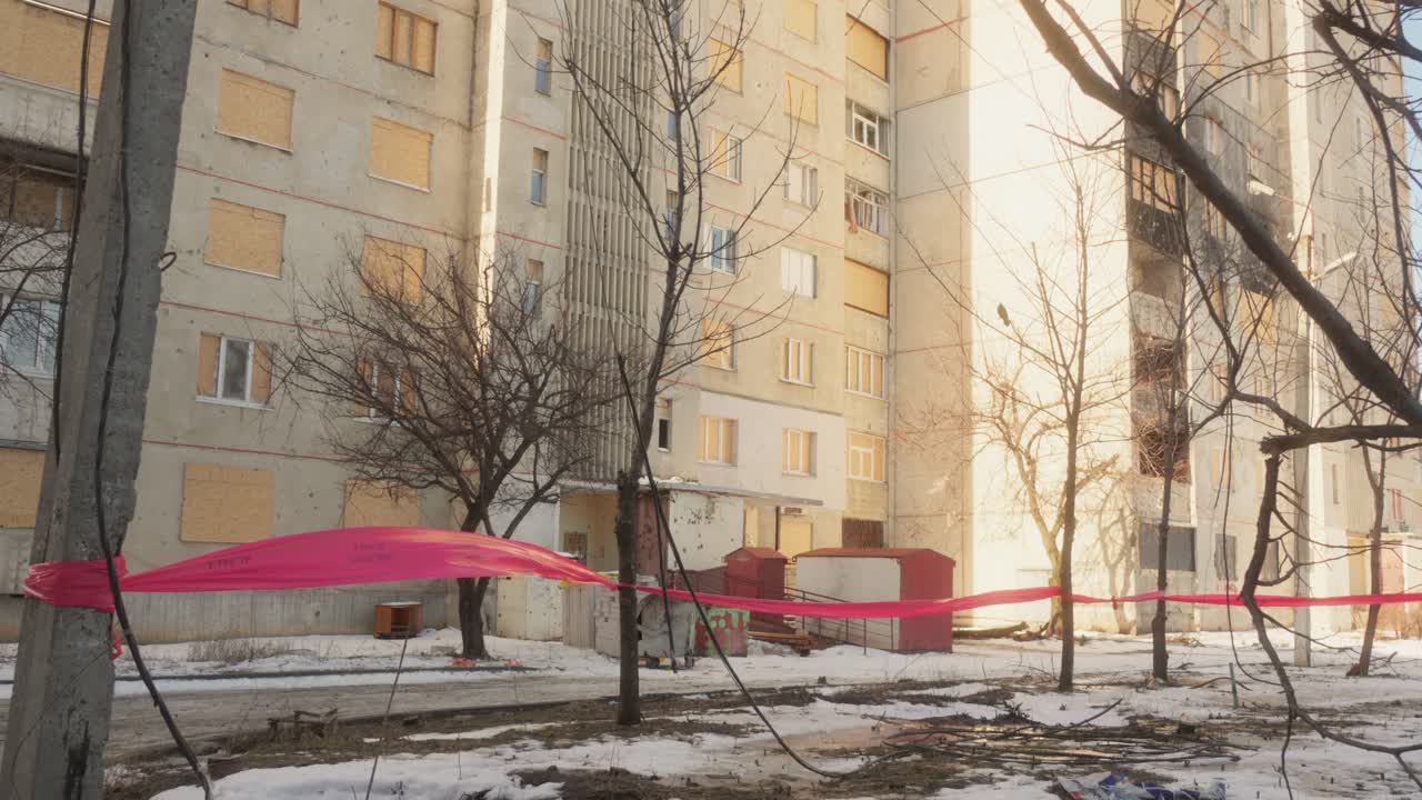 Residential Building with Boarded Windows and Red Tape in War-Damaged Ukrainian City