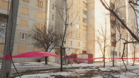 residential building with boarded windows and red tape in war-damaged ukrainian city