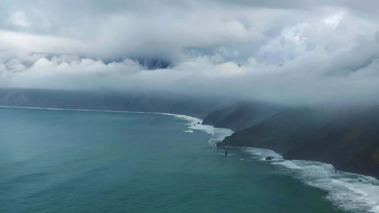 Rugged dramatic untouched coastline USAL Beach campground cloud layer mist rain fog aerial drone California PNW Lost Coast Trail morning surf waves boulder rocks nature landscape circle right
