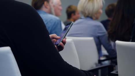 person using smartphone during a conference