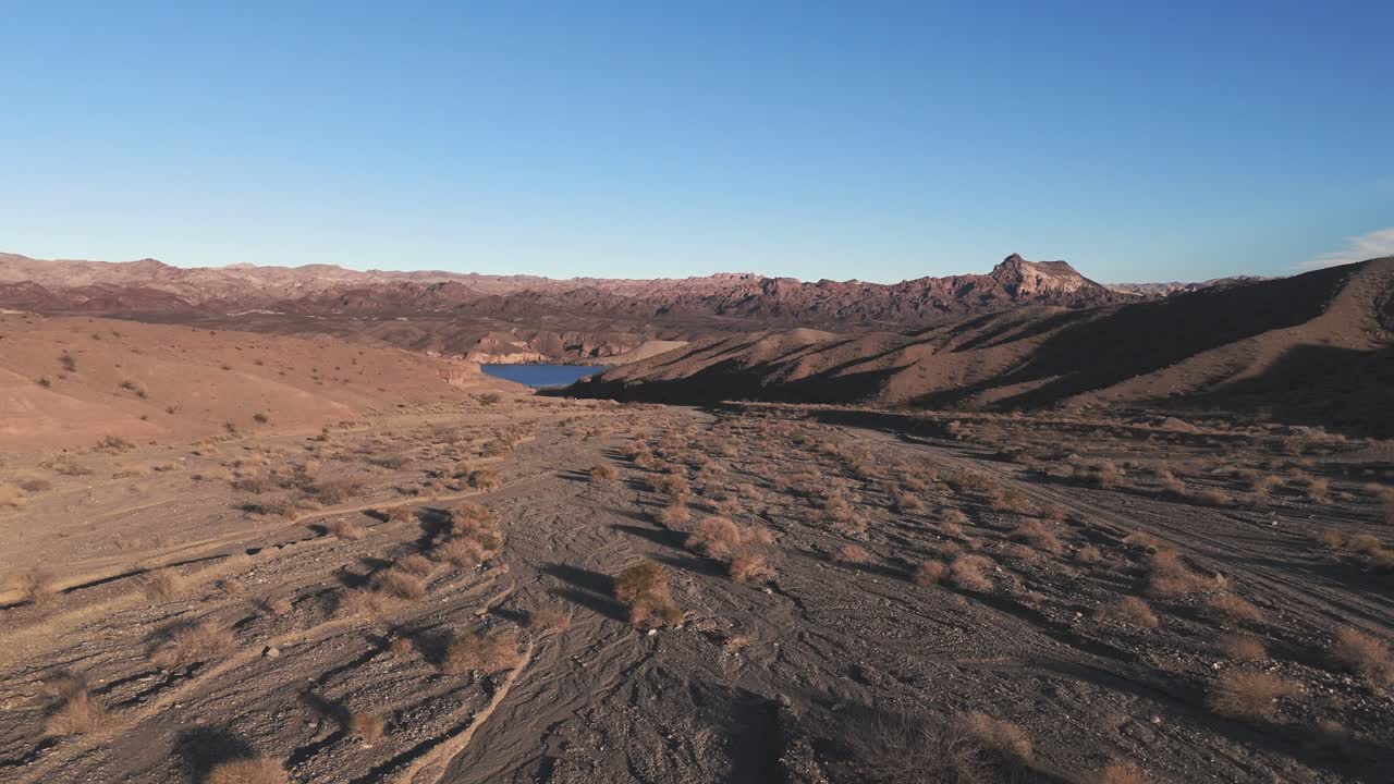 Dry Riverbed Covered in Rocks and Shrubs Heading Into Colorado River