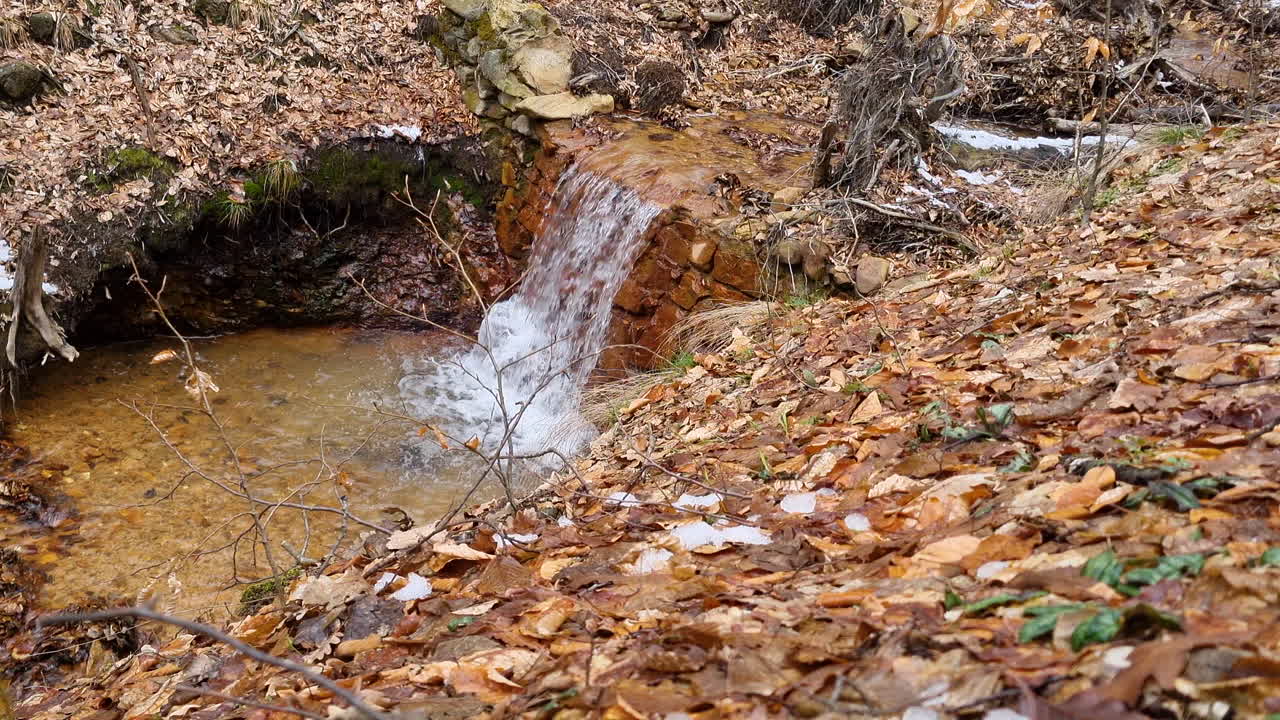 Waterfall of a creek water stream in the woods on a winter day
