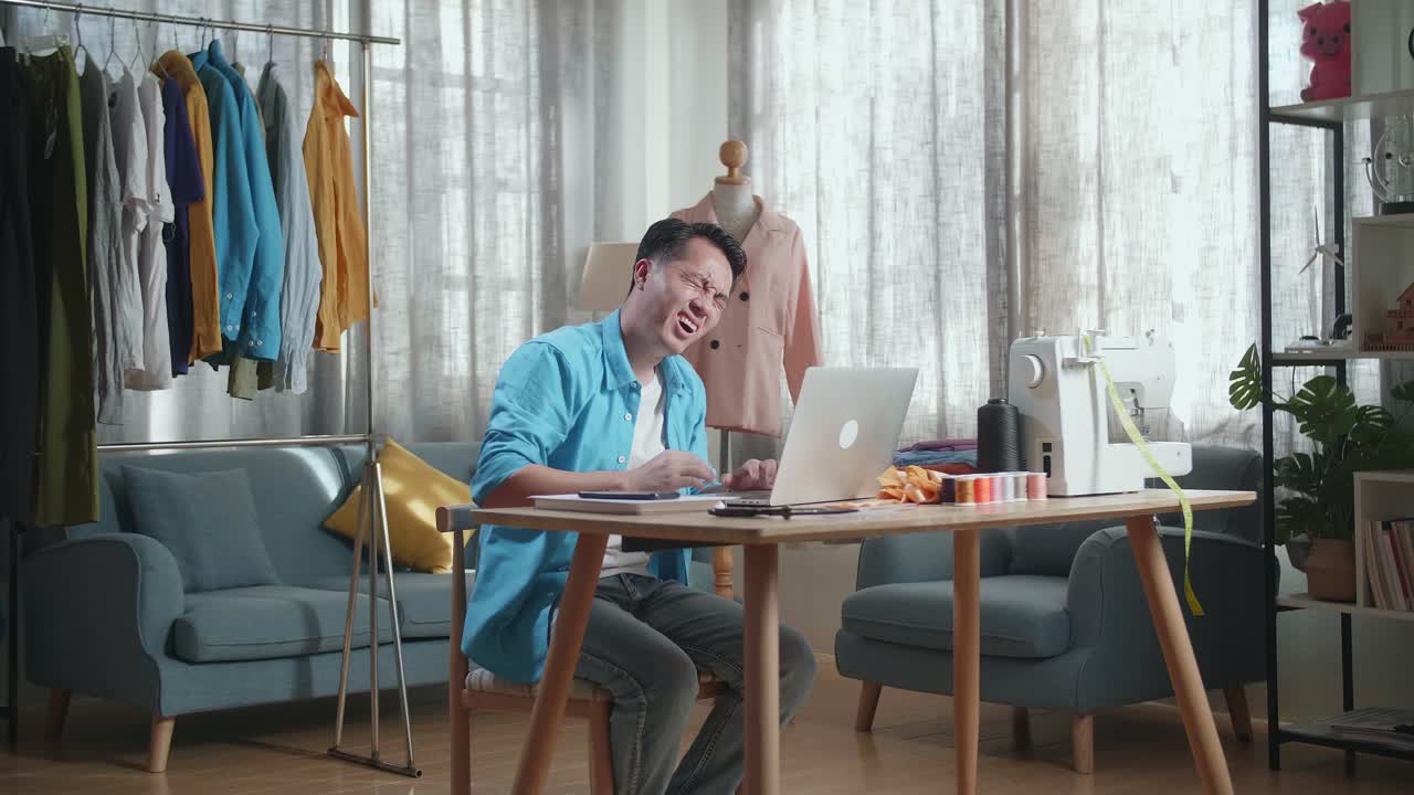 바느질 스튜디오 에서 일 하면서 허리 통증 을 겪는 남자