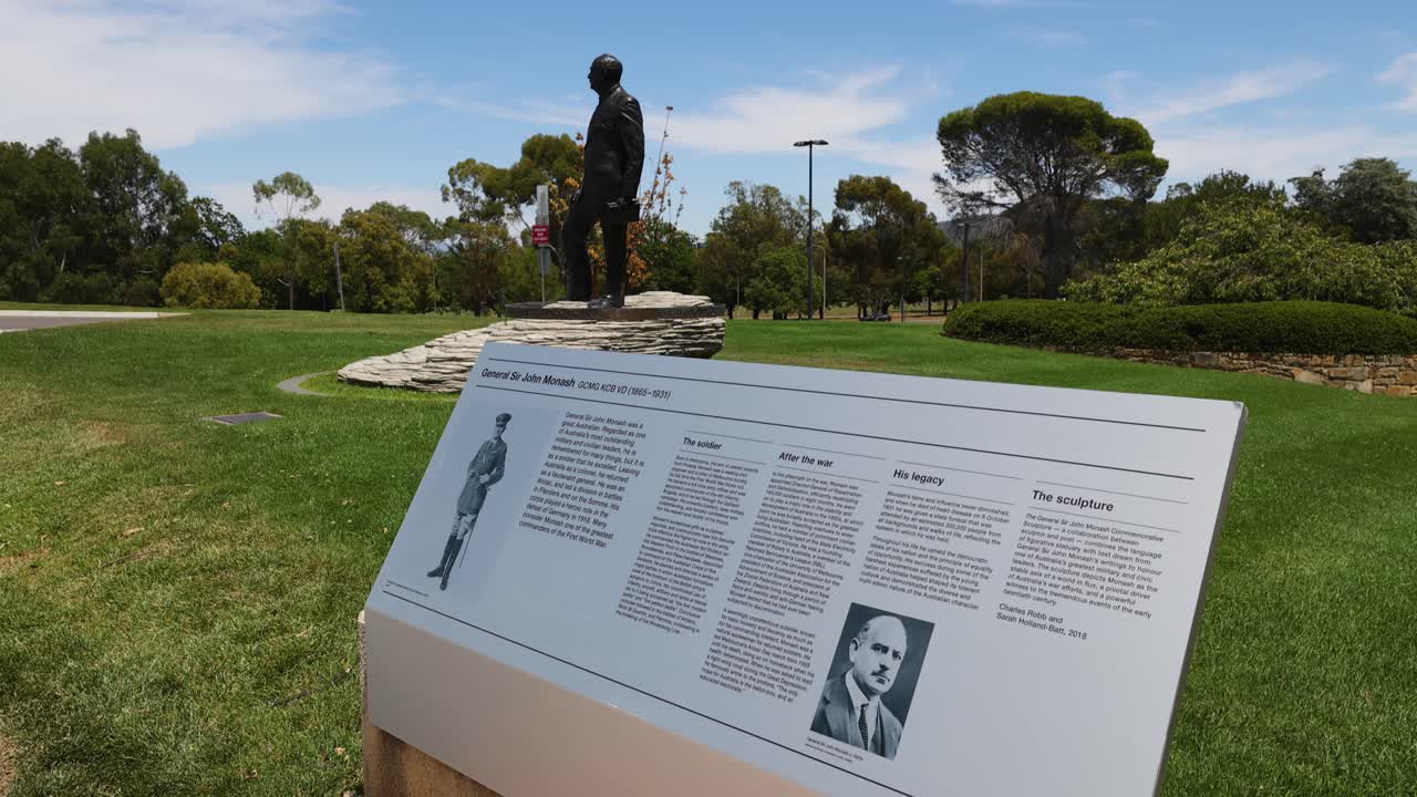 Una lenta panoramica della camera cattura la statua in bronzo e la targa informativa in una giornata di sole