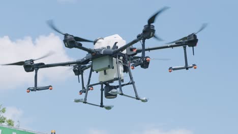 drone pulverizador vuela sobre el campo agrícola. drone agrícola para rociar fertilizante en el cielo azul. agricultura inteligente y agricultura de precisión
