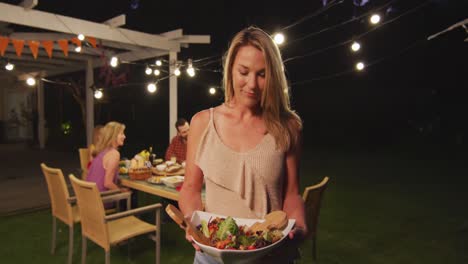 mujer joven sosteniendo bandeja de comida al aire libre