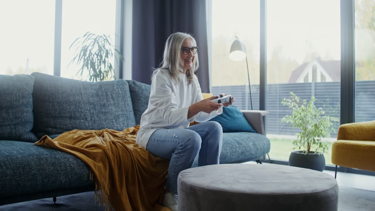 Senior woman playing video game at home