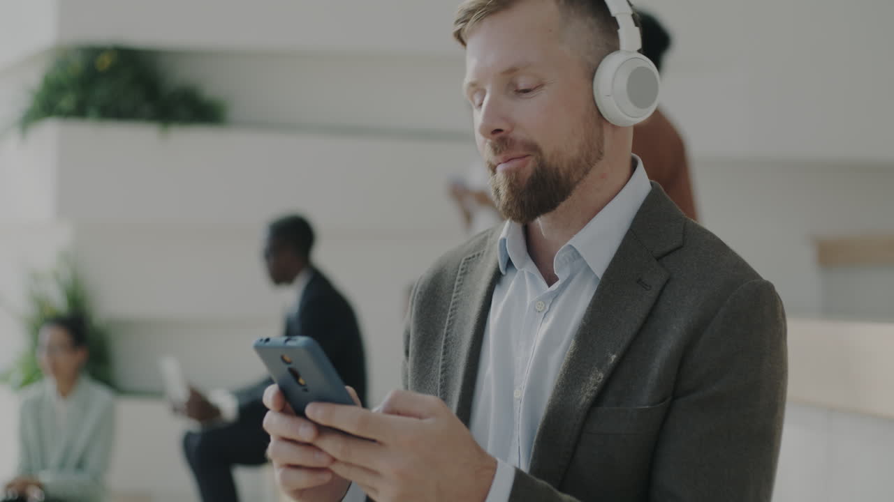 Uomo d'affari che usa lo smartphone nella hall dell'ufficio