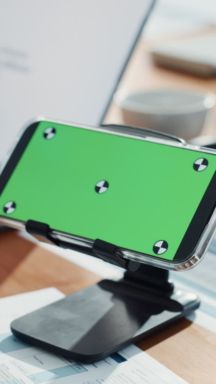 Smartphone con display a schermo verde sulla scrivania