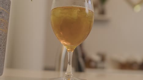 a glass of kombucha drink on white bar table