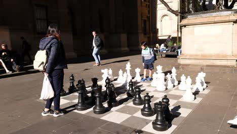 people playing chess on a large outdoor board