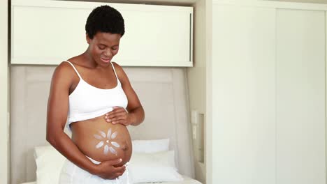 pregnant woman rubbing cream on her belly