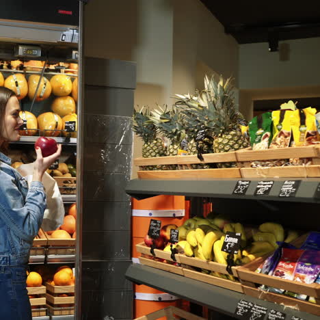 beautiful young woman shopping for fruits and vegetables in a production department. grocery store. supermarket. healthy lifestyle. square video