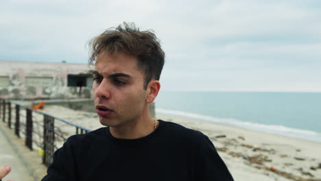 italian guy gesturing in a video call with his angry girlfriend near the sea