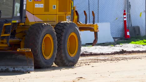 a yellow road grader passing through the screen