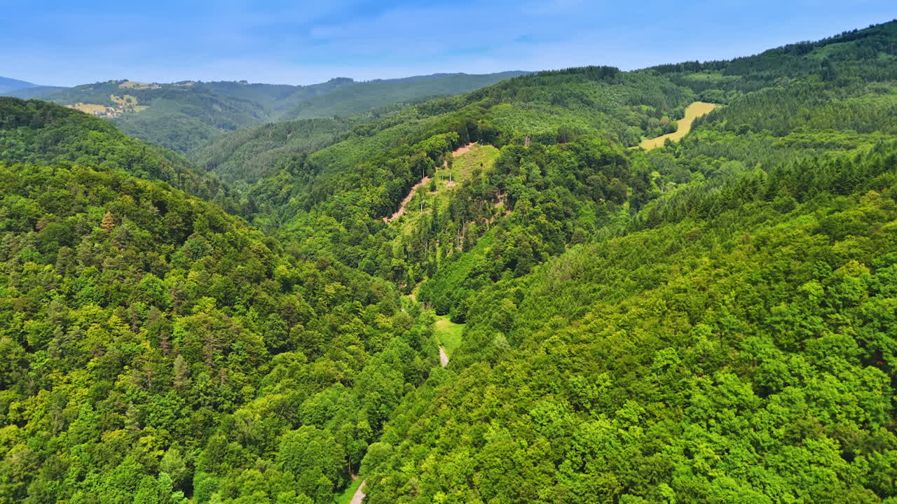 Breathtaking view of lush green hills. A panoramic view showcases the vibrant green hills under a clear blue sky, inviting nature lovers to explore its beauty