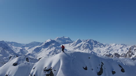 a professional skier hikes up a steep ridge in verbier, then drops into an epic freeride descent. pure adventure skiing in deep snow, dramatic terrain, and breathtaking alpine scenery.