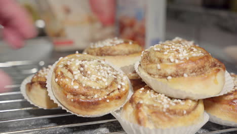 Male-hand-picking-up-a-cinnamon-bun-in-the-foreground