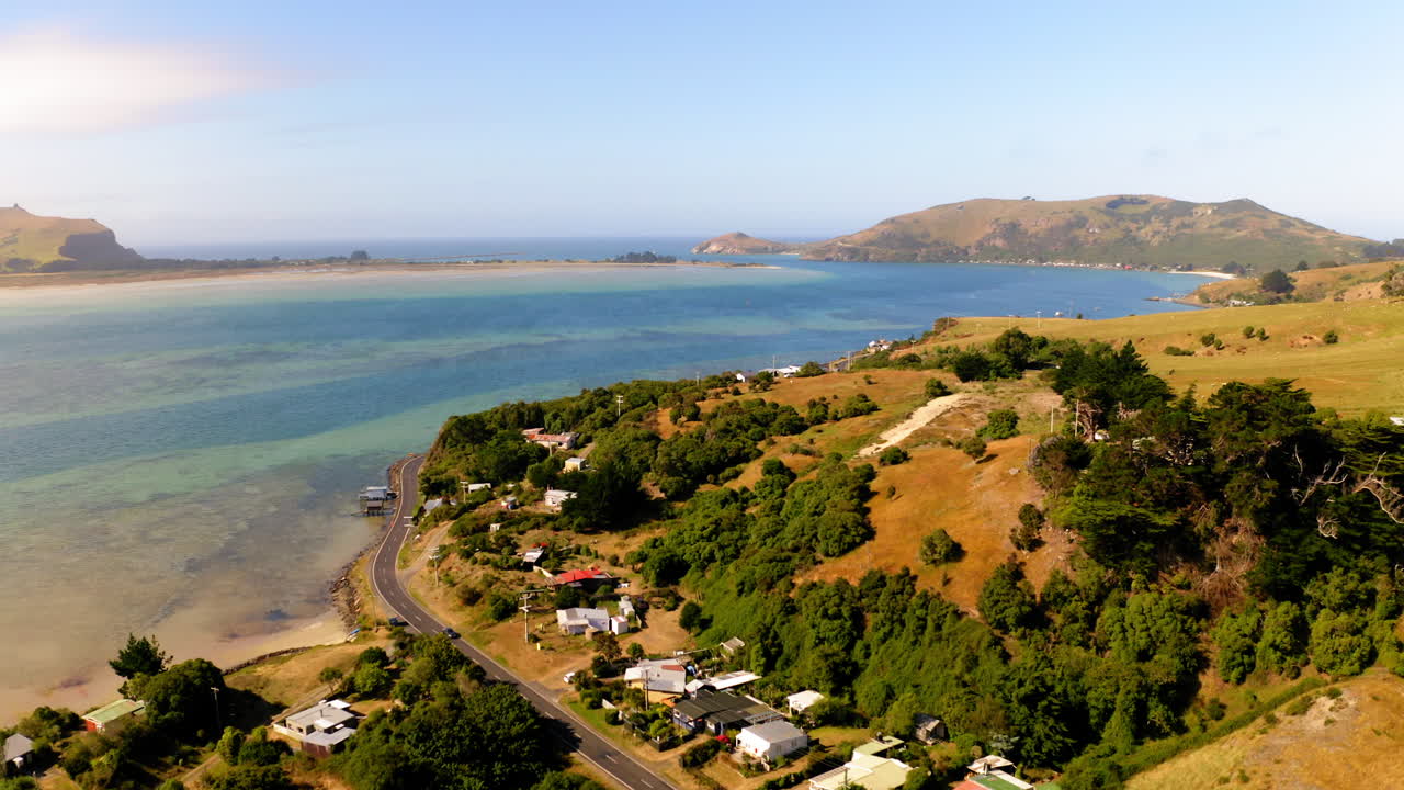 Aerial view of a coastal village and bay nestled among hills
