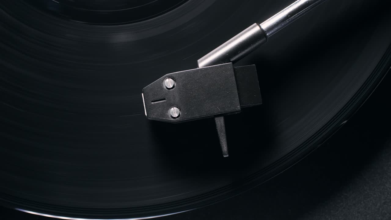 Retro Vinyl record player playing music, close-up macro shot of vintage LP disc old phonograph spinning. Retro music player.