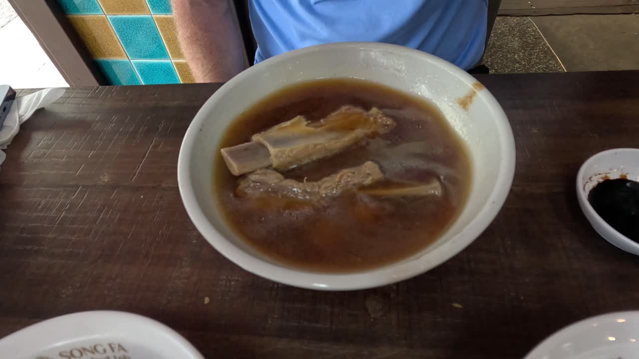 Persona che mangia zuppa con carne e verdure