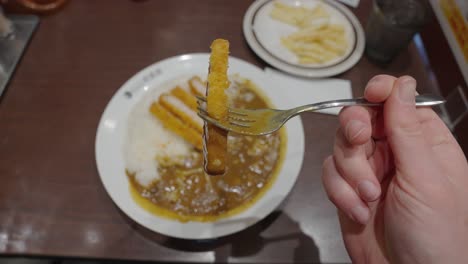 Tonkatsu-cutlet-on-fork,-Close-up-of-Japanese-Style-Curry