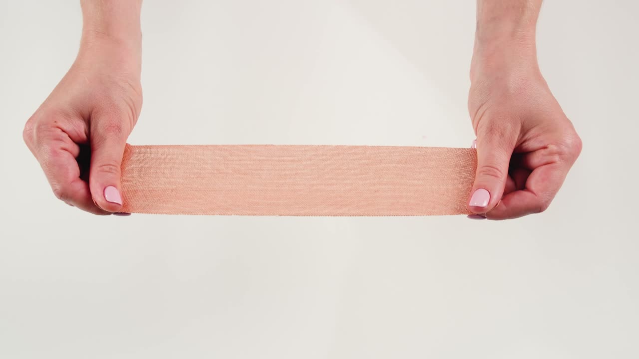 Kinesiology medical taping, doctor Physical therapist applying elastic surgical tape to patient body, treating injured knee young athlete.Post traumatic rehabilitation, sport physical therapy recovery