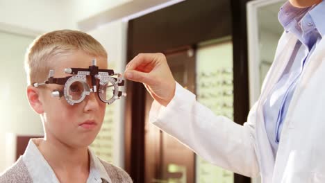 optometrist examining young patient with chiropter