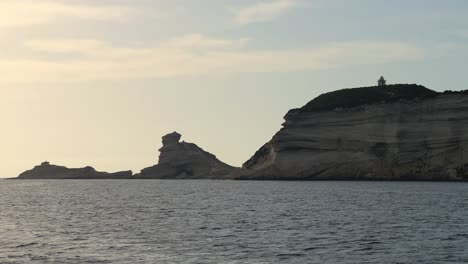 corsica island cliffs and capo pertusato lighthouse seen from mediterranean sea in france, slow motion