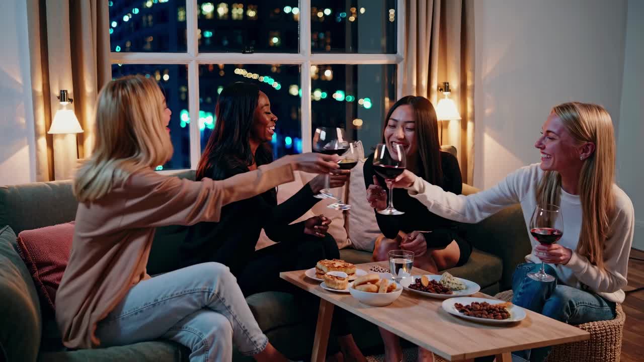 友達がワインと軽食をソファで楽しんでいる、居心地の良い動画シーン。都市のワイドアングルから撮影。