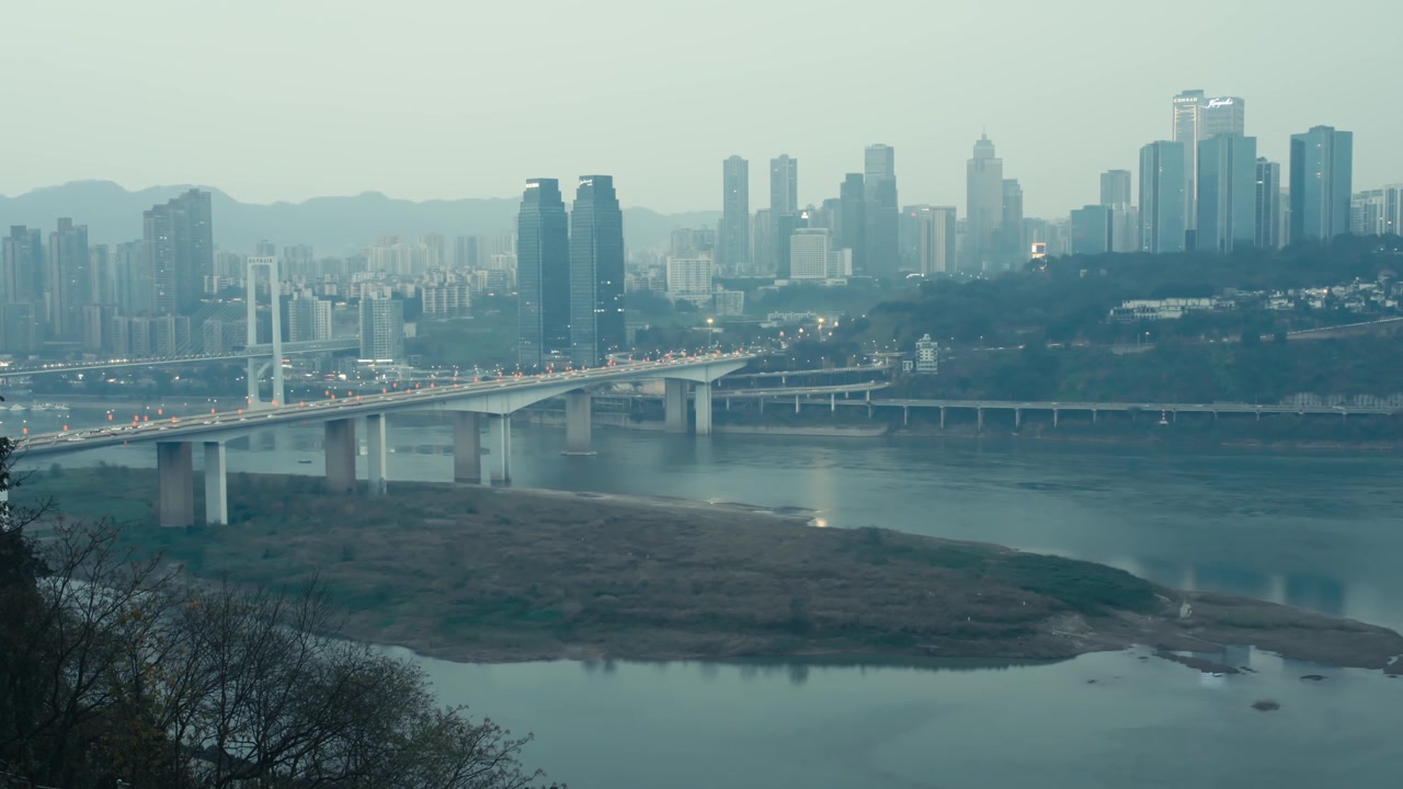 Ponte Shibanpo di Chongqing sul fiume Yangtze al tramonto con lo skyline e il Conrad Hotel.