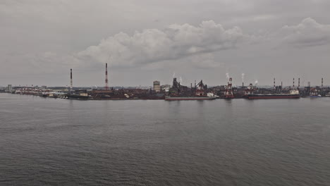 Nagoya-Japan-Aerial-v1-flyover-captures-industrial-port-harbor-with-ships-docked-at-the-shore-of-Steel-Furnace-Plant-in-Tokaimachi-on-a-gloomy-overcast-day---Shot-with-Mavic-3-Pro-Cine---October-2023